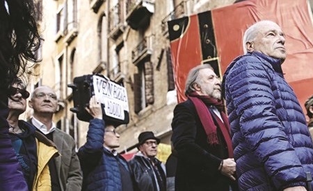 متظاهرون يحملون حقائبهم احتجاجا على تدفق السياح