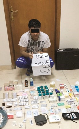 الوافد الهندي وأمامه بعض الأدوية والعلاجات لممارسة الطب