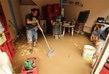  رجل يحاول تنظيف منزله من المياه والوحل