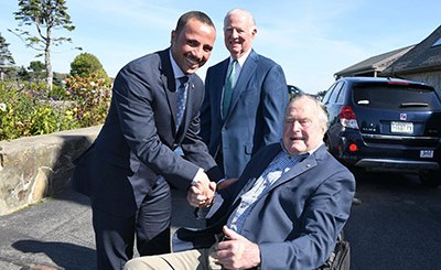 الرئيس الغانم مصافحا جورج بوش ويبدو جيمس بيكر