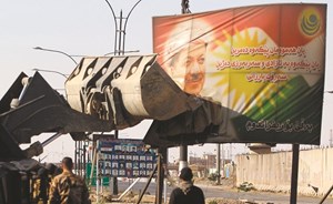 جرافة عراقية تحطم لافتة كبيرة تحمل صورة زعيم كردستان مسعود بارزاني في كركوك	(أ.ف.پ)
