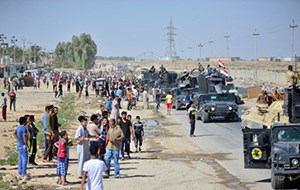 مواطنون عراقيون يرحبون بأفراد الجيش الذين يواصلون تقدمهم باتجاه كركوك (رويترز)