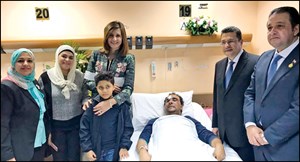الوزيرة نبيلة مكرم خلال زيارتها المواطن المصري بحضور السفير المصري وأسرة المصاب (أحمد علي)