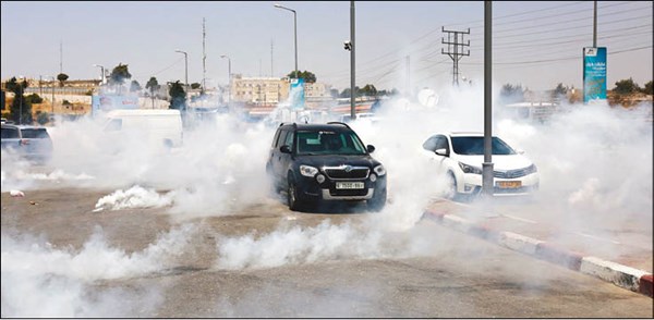 سيارات فلسطينية عالقة وسط الغاز المسيل للدموع اطلقته قوات الاحتلال على محتجين في رام الله                      (أ.ف.پ)