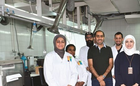 ليلى غفران وعبدالله اليتيم يتوسطان عددا من فريق العمل في المختبرات