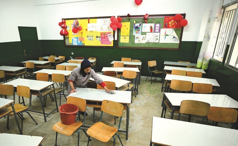 عاملة تنظف فصلا في مدرسة مغلقة كإجراء وقائي ضد انتشار ڤيروس كورونا في صيدا أمس	(رويترز)