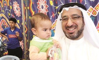 ويحمل طفلا في احد المخيمات