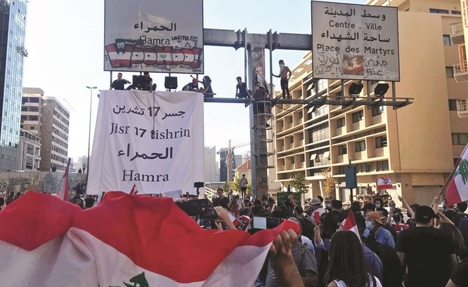 المتظاهرون يرفعون لافتة تحمل اسم جسر 17 تشرين الأول فوق جسر الرينغ أمس