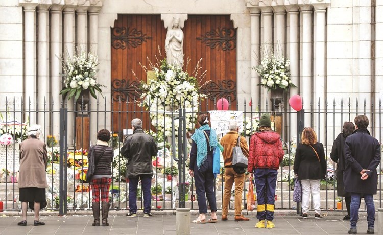 اشخاص يضعون الزهور تخليدا لذكرى ضحايا كنيسة نيس في فرنسا 	(أ.ف.پ)