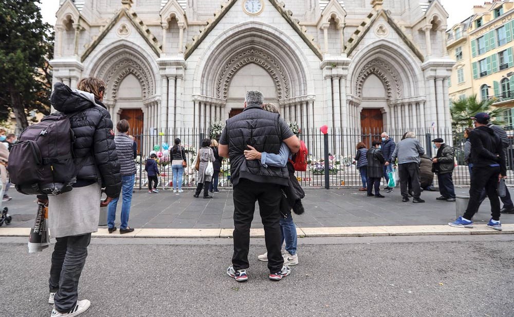  فرنسيون يضعون الزهور ويحيون ذكرى ضحايا هجوم كاتدرائية نوتردام في نيس.. وفي الإطار الرئيس الفرنسي ايمانويل ماكرون متحدثا لقناة الجزيرة (أ.ف.پ)