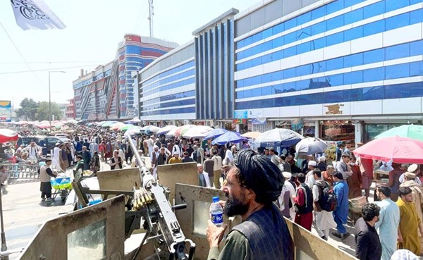 عناصر أمن تابعون لطالبان يقومون بالحراسة في احد اسواق العملات في كابول	(رويترز)
