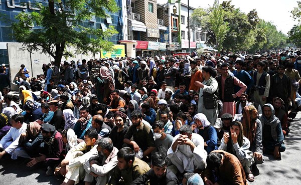 أفغان ينتظرون لسحب أموالهم أمام أحد البنوك في كابول (أ.ف.پ)